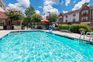 a swimming pool with blue water in a apartment complex at TownePlace Suites by Marriott Atlanta Kennesaw in Kennesaw