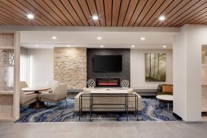 a living room with a fireplace and a tv at Fairfield Inn & Suites Atlantic City Absecon in Galloway