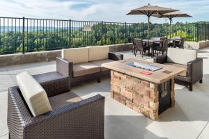 un patio con sillas, mesas y una sombrilla en Fairfield Inn & Suites by Marriott Huntington, en Huntington