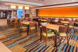 Fairfield Inn & Suites by Marriott Huntington في هنتنجتون: غرفة طعام مع طاولات وكراسي خشبية