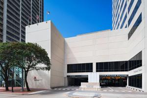 un gran edificio blanco con un banco delante en Houston Marriott Medical Center/Museum District en Houston