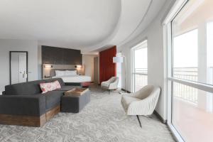 ein Hotelzimmer mit einem Bett, einem Sofa und einem Stuhl in der Unterkunft SpringHill Suites by Marriott Auburn in Auburn