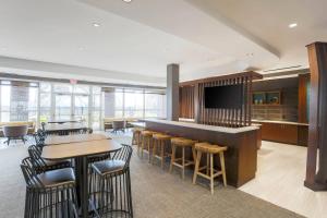 a lobby with a bar and tables and chairs at SpringHill Suites by Marriott Auburn in Auburn