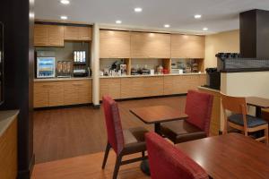 a restaurant with tables and chairs and a kitchen at TownePlace Suites by Marriott Danville in Danville