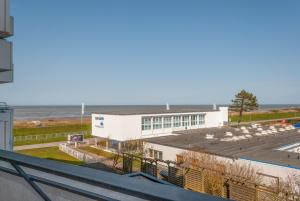 une vue d'un bâtiment avec l'océan en arrière-plan dans l'établissement Haus Hanseatic, Wohnung 312, à Duhnen