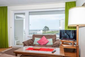 un salon avec un canapé et une grande fenêtre dans l'établissement Haus Hanseatic, Wohnung 312, à Duhnen