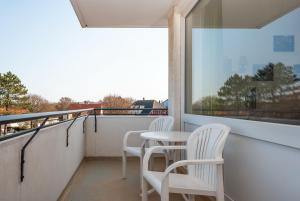 d'un balcon avec deux chaises, une table et une fenêtre. dans l'établissement Haus Hanseatic, Wohnung 312, à Duhnen
