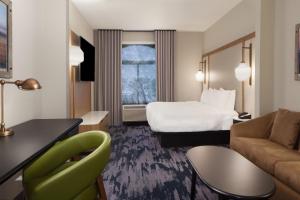 Habitación de hotel con cama y sofá en Fairfield Inn & Suites by Marriott Charleston en Charleston