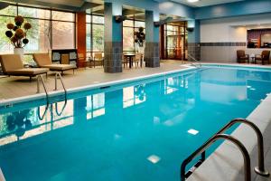 una piscina in un hotel con sedie e tavoli di Marriott Cincinnati North a West Chester