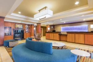 Fairfield Inn & Suites Columbia في كولومبيا: غرفة معيشة مع أريكة زرقاء وطاولات