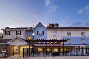 a large white building with a black fence at TownePlace Suites by Marriott Baton Rouge South in Baton Rouge