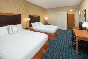 a hotel room with two beds and a desk at Fairfield Inn and Suites Cleveland in Cleveland