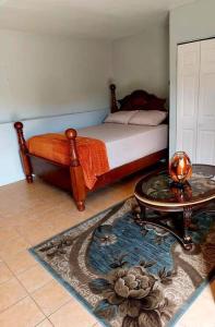 1 dormitorio con 1 cama y 1 mesa con mesa de centro en Comfort Cottage at the Grove en Mandeville