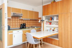 een keuken met houten kasten en een tafel en stoelen bij Haus Hanseatic, Wohnung 512 in Duhnen