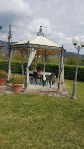 cenador con mesa y sillas en un patio en leupupe relax cultura mare monti, en Cascina