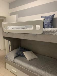 two bunk beds in a room with a pillow at leupupe relax cultura mare monti in Cascina