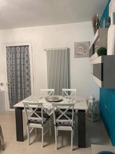 a dining room with a table and chairs and a radiator at leupupe relax cultura mare monti in Cascina