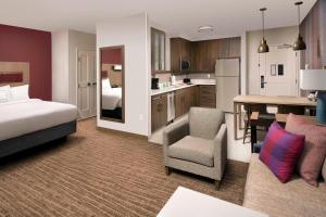 a room with a bed and a kitchen with a table at Residence Inn by Marriott Baltimore Owings Mills in Owings Mills
