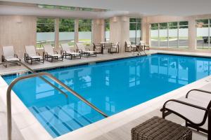 a large swimming pool with chairs and a table at Residence Inn by Marriott Baltimore Owings Mills in Owings Mills