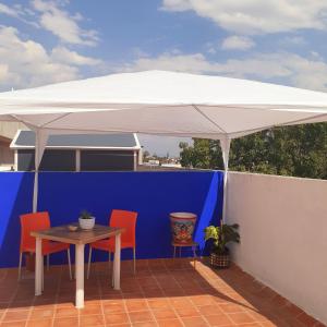 una sombrilla blanca en un patio con sillas y mesa en Rooftop Paradise Central Location, Scenic Views, en Ciudad de México