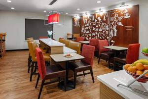 un restaurante con mesas y sillas y una pizarra en TownePlace Suites by Marriott Dallas Plano/Legacy, en Plano