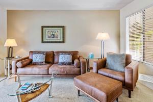 a living room with a couch and chairs and a table at Mesquite Condo in the Sun in Palm Springs