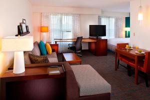 Habitación de hotel con sofá, cama y escritorio. en Residence Inn Baton Rouge Siegen, en Baton Rouge