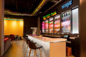 a bar with a row of stools in a room at Aloft Coral Gables in Miami