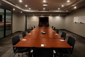 une salle de conférence avec une grande table et des chaises en bois dans l'établissement Aloft Coral Gables, à Miami