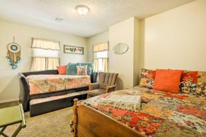 ein Schlafzimmer mit einem Bett und einem Sofa in der Unterkunft Charming Craftsman Home in Downtown Bartlesville! in Bartlesville