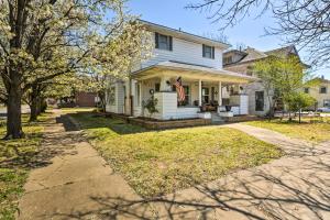 Charming Craftsman Home in Downtown Bartlesville! في بارتلسفيل: بيت أبيض عليه علم أمريكي