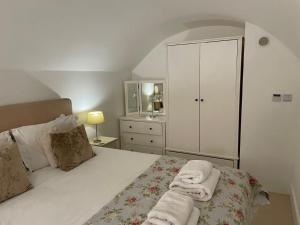 1 dormitorio con 1 cama con toallas en Beautiful 3 Bed Basement Flat With Garden, en Bath