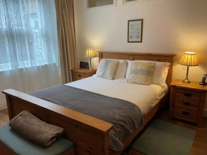 Un dormitorio con una cama grande y una ventana en Beautiful 3 Bed Basement Flat With Garden, en Bath