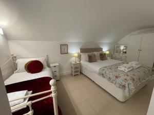 1 dormitorio con 2 camas y 2 lámparas. en Beautiful 3 Bed Basement Flat With Garden, en Bath