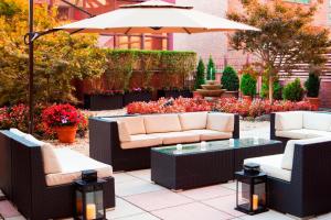 a patio with couches and a table and an umbrella at Sheraton LaGuardia East Hotel in Queens