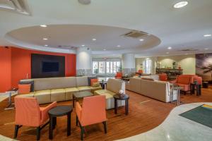a lobby with a couch and tables and chairs at Courtyard by Marriott Jacksonville Beach Oceanfront in Jacksonville Beach