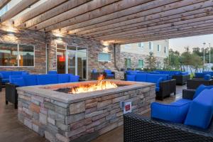 eine Feuerstelle auf einer Terrasse mit blauen Stühlen in der Unterkunft Fairfield Inn & Suites by Marriott Alexandria in Alexandria
