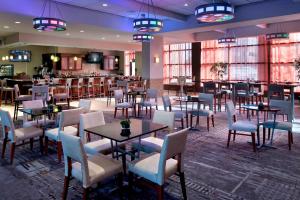 een restaurant met tafels en stoelen en een bar bij Marriott Albany in Albany