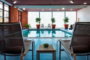 een zwembad met 2 stoelen en een tafel bij Marriott Albany in Albany