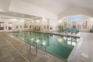 una gran piscina con sillas verdes en un edificio en Residence Inn Dallas DFW Airport South/Irving en Irving