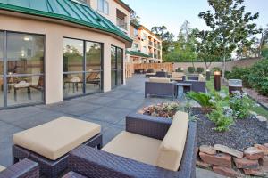 a patio with benches and tables and chairs at Courtyard Houston The Woodlands in The Woodlands