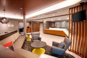 a lobby with a waiting room with chairs and a tv at SpringHill Suites by Marriott Hampton Portsmouth in Hampton