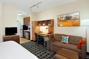 TownePlace Suites by Marriott New Orleans Harvey/West Bank في هارفي: غرفة معيشة مع أريكة ومكتب في غرفة