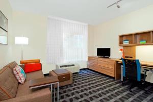TownePlace Suites by Marriott New Orleans Harvey/West Bank في هارفي: غرفة معيشة مع أريكة وتلفزيون