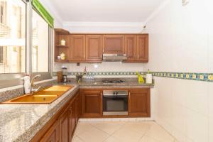 a kitchen with wooden cabinets and a sink and a window at Appartement Haut Standing Central Corniche in Tangier