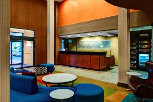 a lobby with two tables and chairs and a counter at Fairfield Inn & Suites by Marriott Anniston Oxford in Oxford