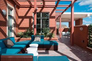 een patio met blauwe meubels in een bakstenen gebouw bij SpringHill Suites Houston Sugarland in Sugar Land