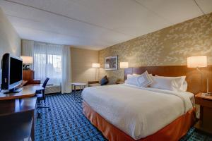 a hotel room with a large bed and a desk at Fairfield Inn Boston Woburn in Woburn
