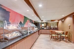 a restaurant with a counter with a table and chairs at Fairfield Inn Boston Woburn in Woburn