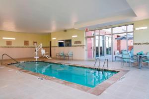 a large swimming pool with a table and chairs at SpringHill Suites Houston Sugarland in Sugar Land